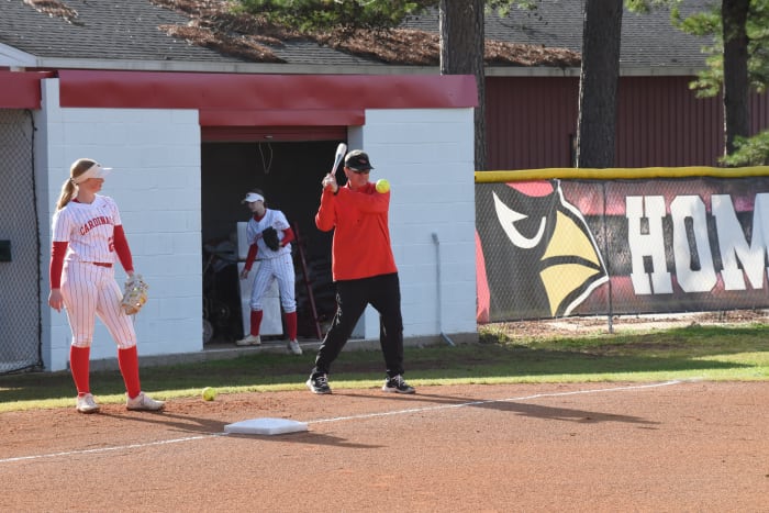 Farmington head coach Jason Shirey warming up with his team during the Farmington Tournament as junior Mallory Sills watches. Sills hit the go-ahead, three-run home run against Springdale Har-Ber that secured the 8-6 win for the Lady Cardinals in the final. (Photo by Kyle Sutherland)